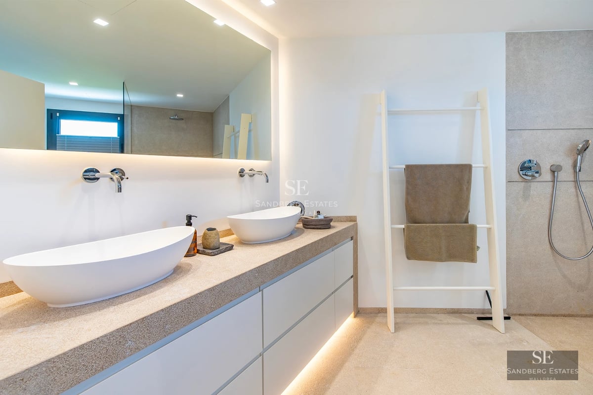 Exterior view of modern villa featuring an infinity pool, lounge chairs, and lush greenery. Minimalist and elegant architectural design.