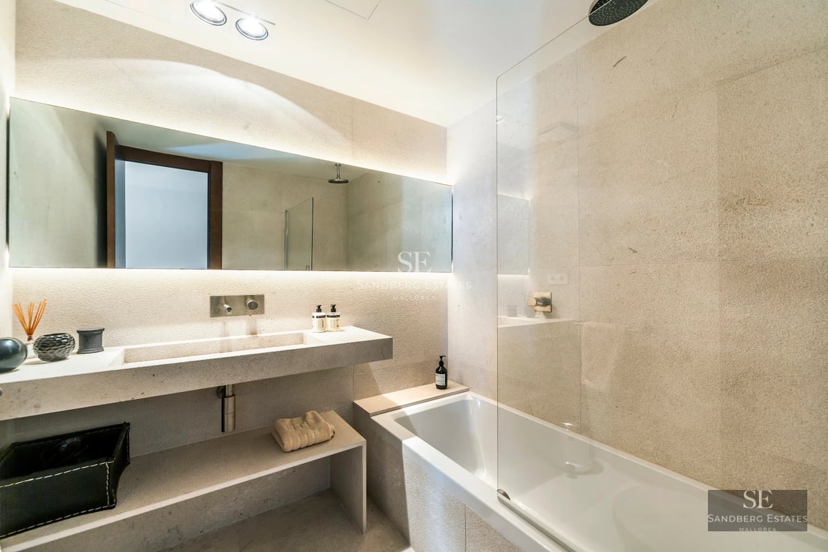 Exterior view of a modern villa featuring an infinity pool, spacious terrace, and lush vegetation. Minimalist architecture and high-end finishes.