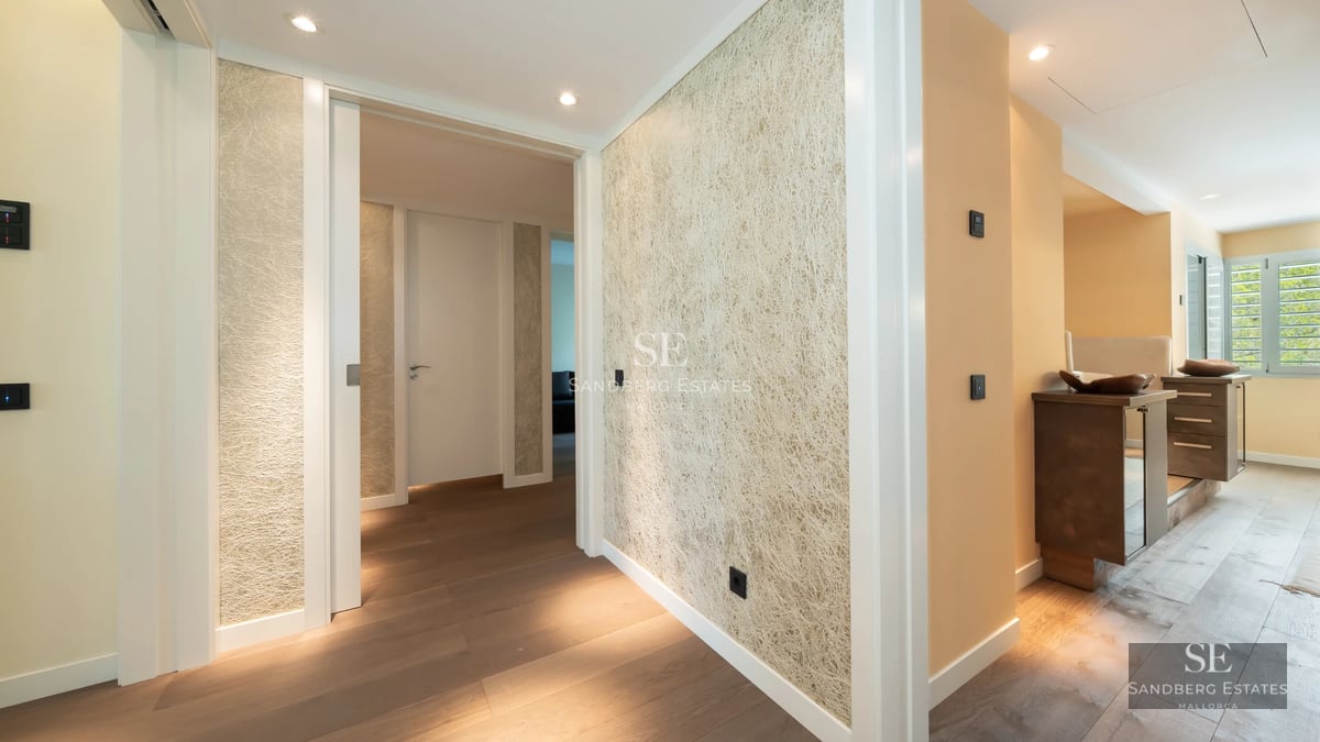 Spacious terrace with pool and panoramic views. Modern design, glass railing, wooden floors, and stylish sun loungers.