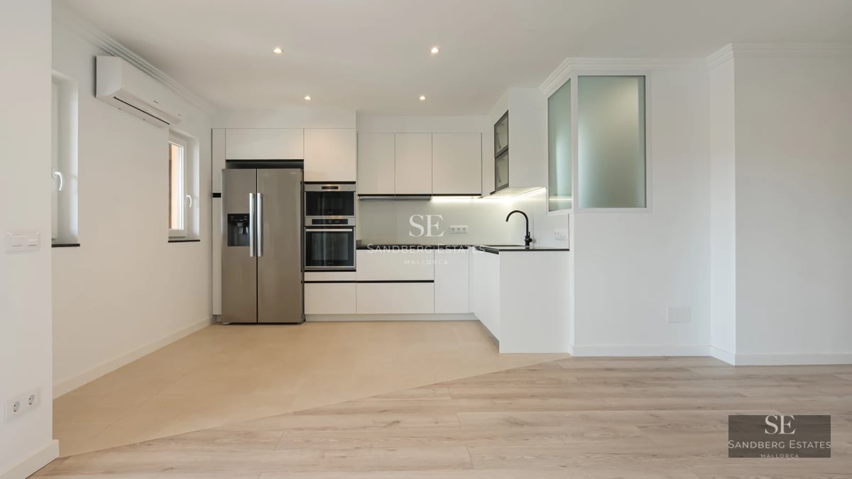 Spacious terrace with glass railing and panoramic sea views. Modern furniture, wooden floor. Ambient lighting.