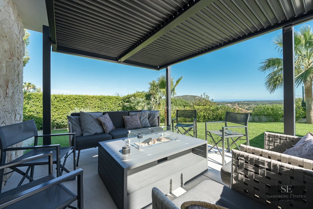 Spacious balcony with panoramic sea views. Modern, minimalist design with glass railing and outdoor furniture.