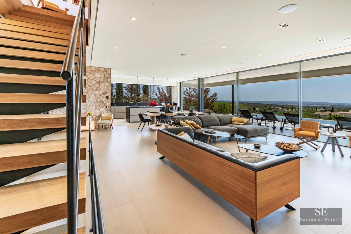 Spacious balcony with ocean view. Glass railing, wood flooring, and modern furniture. Elegant and bright design.