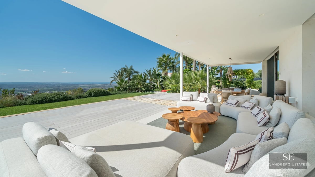 Spacious balcony with panoramic sea views. Modern furniture, glass railing, wood flooring. Ambient lighting. Luxury and comfort.