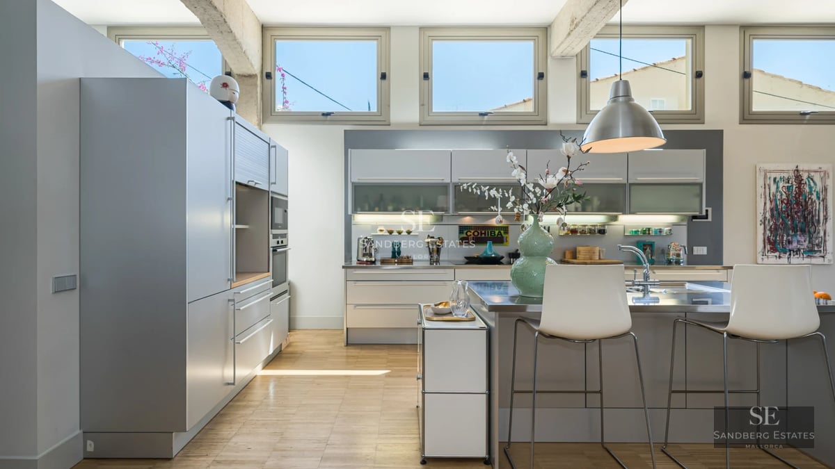 View of an infinity pool surrounded by a lush garden. Modern architecture with large windows maximizing natural light.