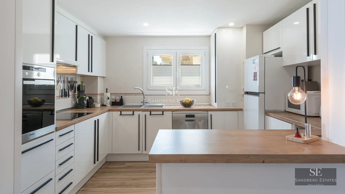 Spacious, bright living room with large windows, modern furniture, wooden floors, and garden views. Contemporary architecture.