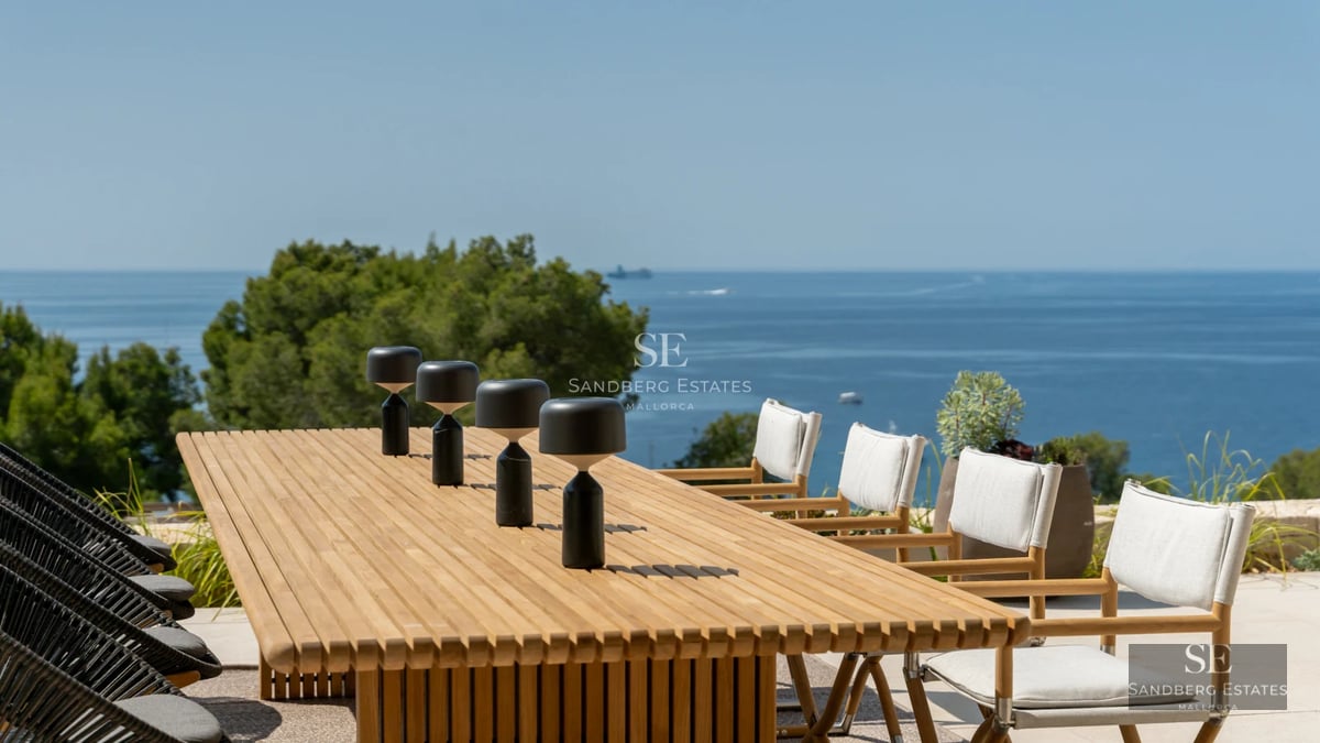 Spacious balcony overlooking the sea. Modern design, glass railing, elegant furniture. Ideal for relaxing and enjoying the scenery.