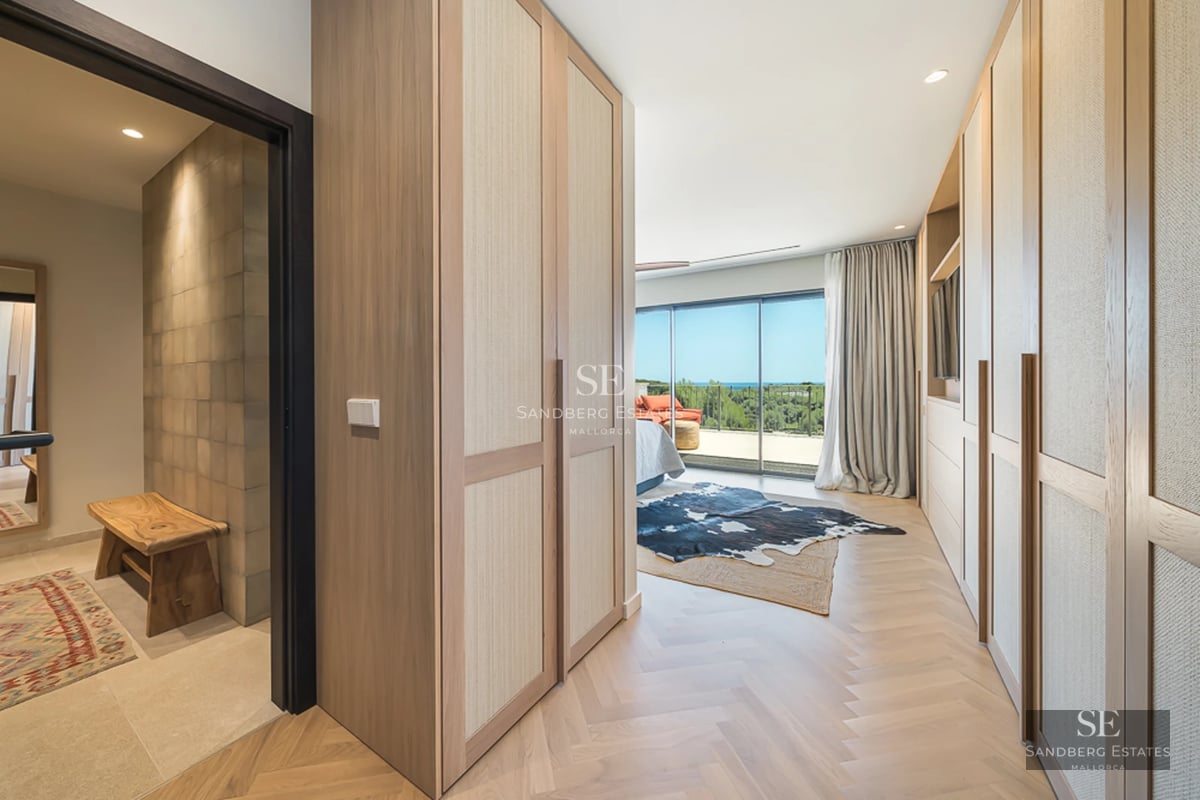 Vaste salon avec grandes baies vitrées, parquet clair, cheminée moderne et mobilier design minimaliste. Lumière naturelle abondante.