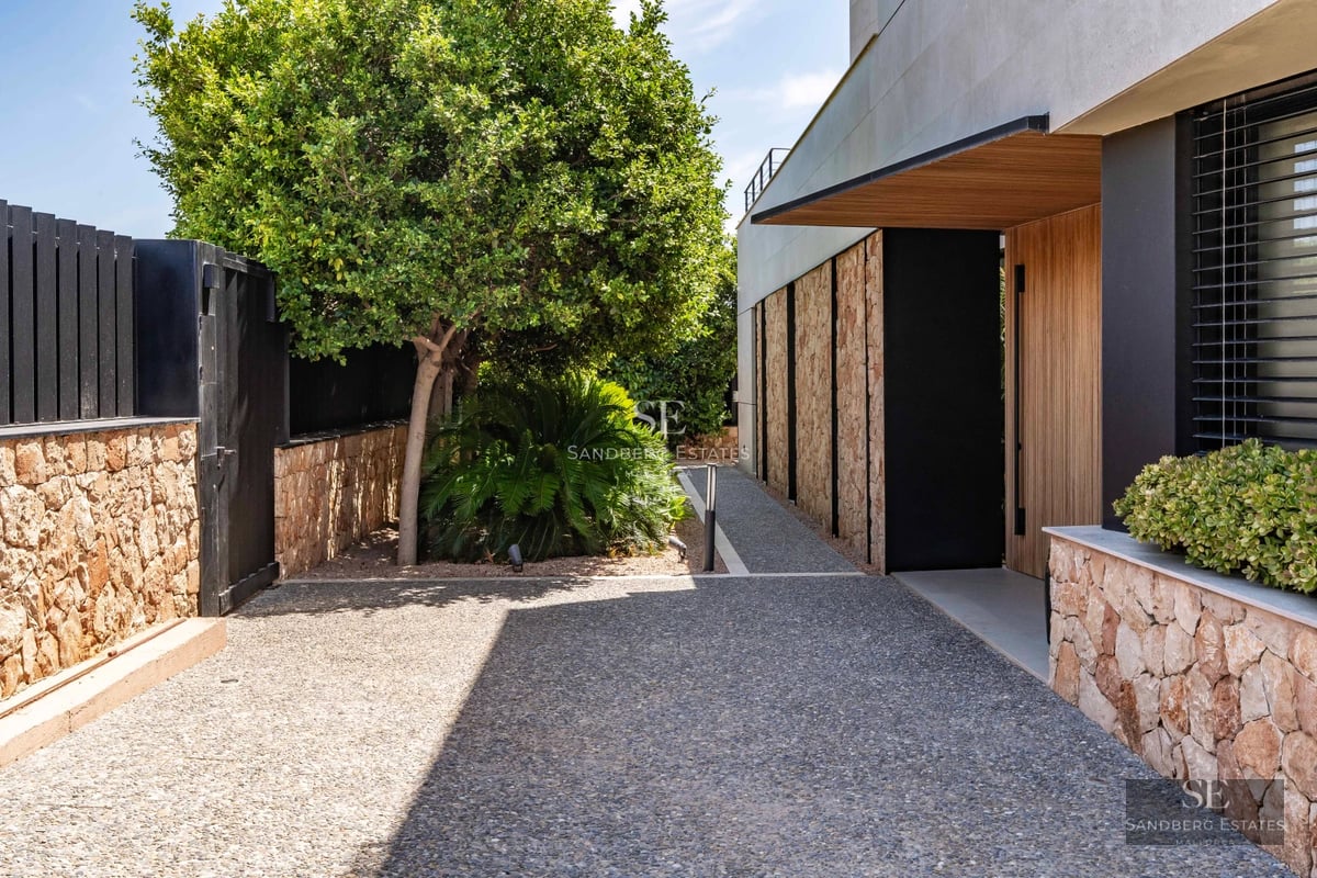 Spacious exterior with turquoise pool, modern sun loungers, and lush greenery. Minimalist and elegant design.