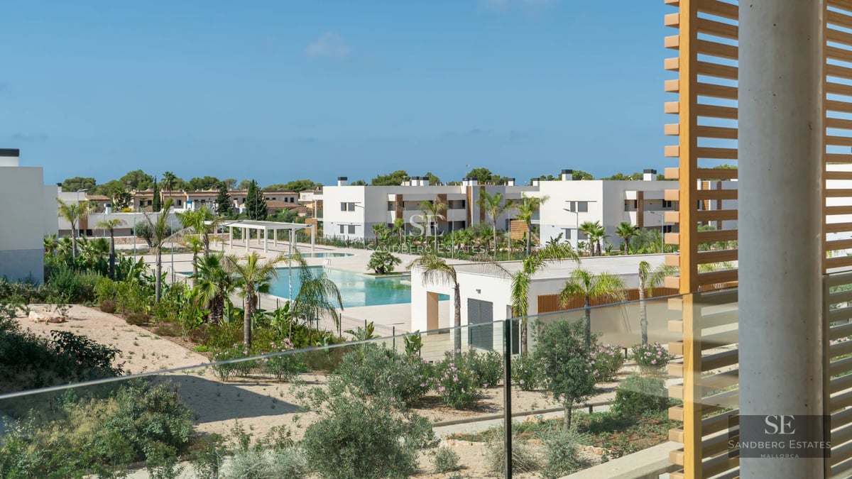 Spacious living room with floor-to-ceiling windows, modern furniture, and access to terrace with pool. Natural light and minimalist design.