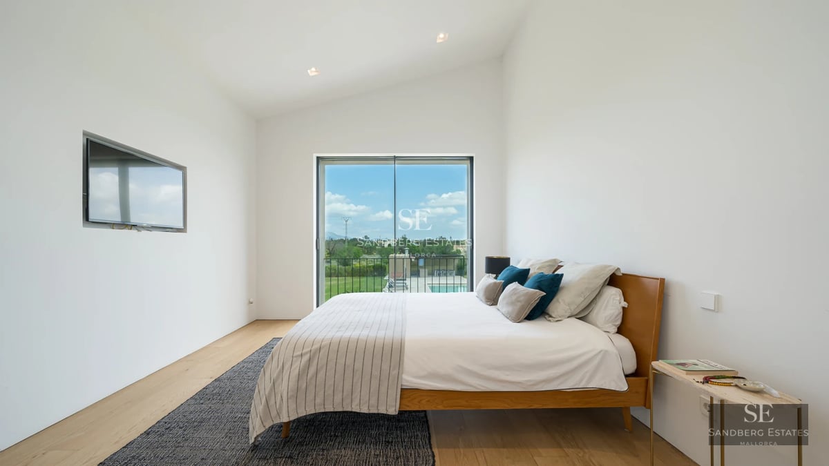 Aerial view of a luxurious villa featuring an infinity pool, lush garden, and modern architectural design. Warm and elegant lighting.