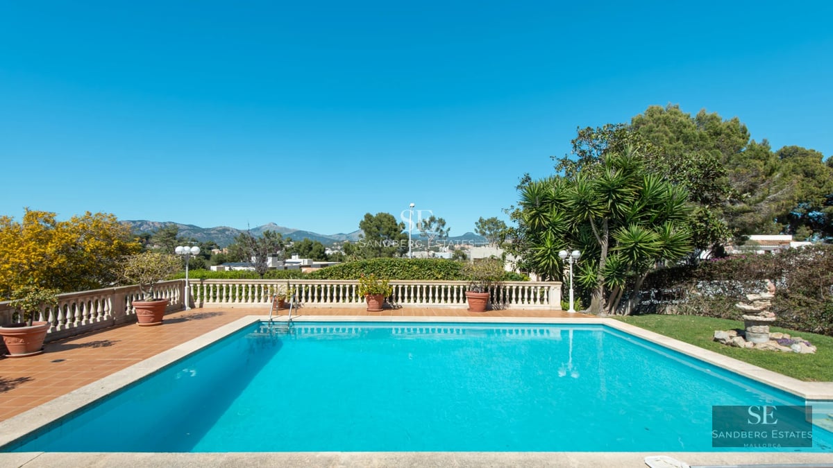 Exterior view of a modern villa with a pool, lush garden, and large terraces. Sleek, minimalist design with abundant natural light.