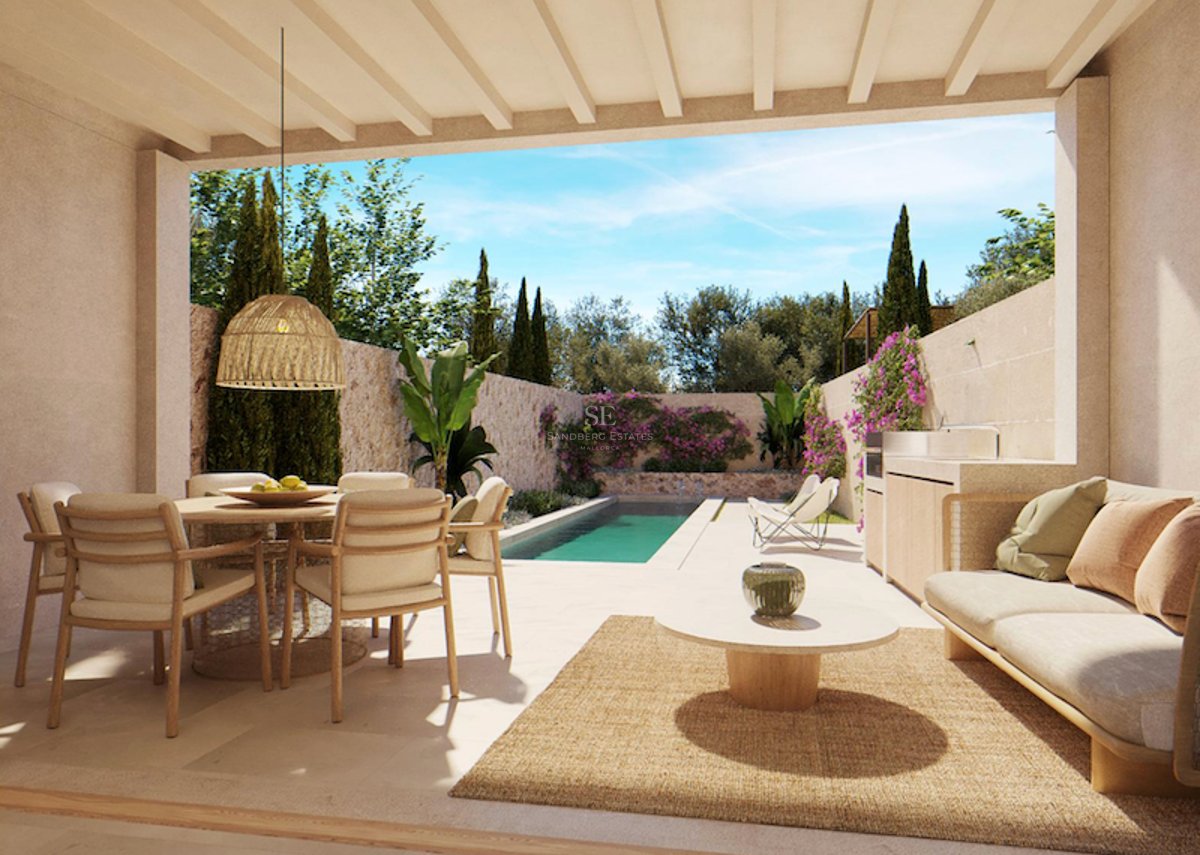 Terrasse couverte avec salle à manger, canapé et cuisine extérieure donnant sur une piscine et un jardin luxuriant.