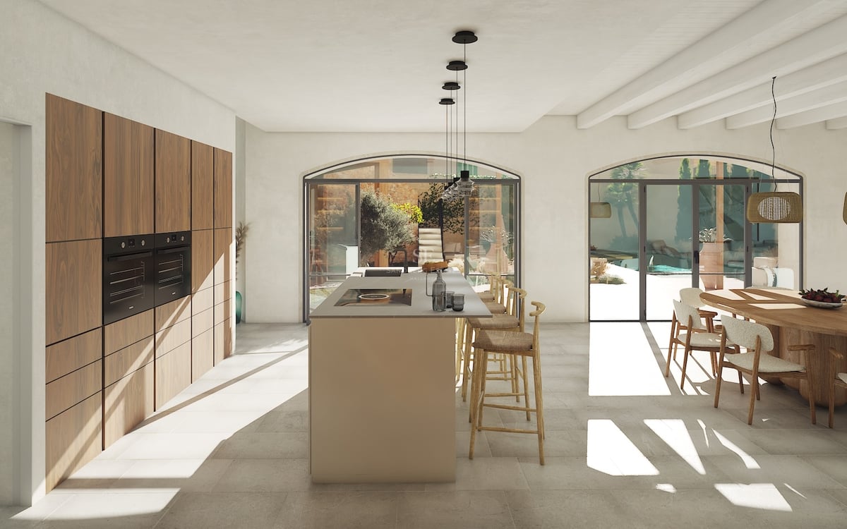 Cuisine moderne à aire ouverte avec îlot central, menuiserie en noyer et portes vitrées cintrées donnant sur un patio.