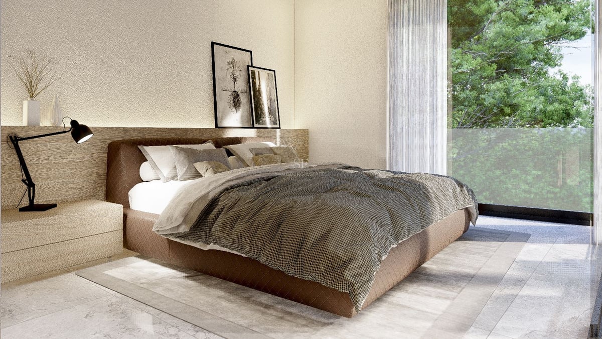 Chambre moderne avec grand lit marron et baies vitrées donnant sur une végétation luxuriante.