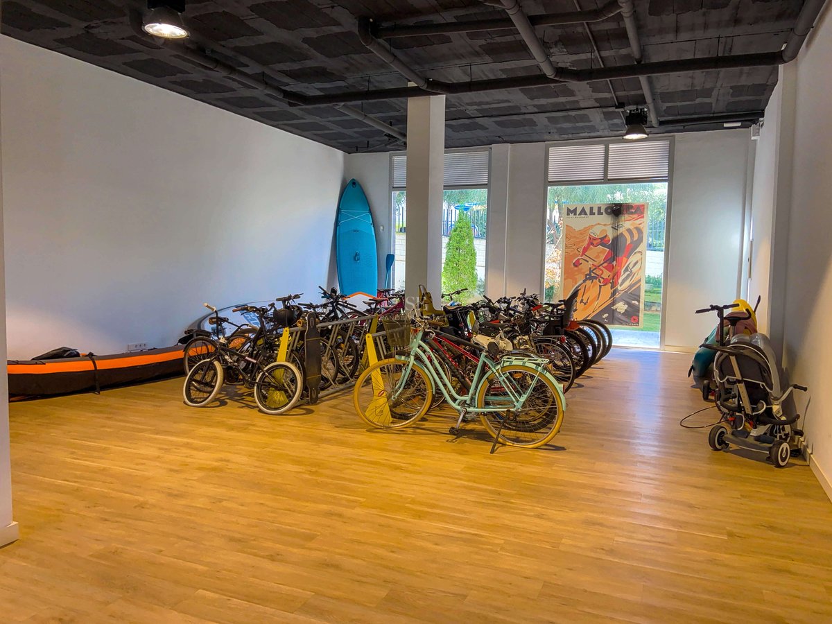 Großzügiger Lagerraum mit Fahrrädern, SUP-Boards und Kayak auf hochwertigem Holzboden mit industrieller Decke.