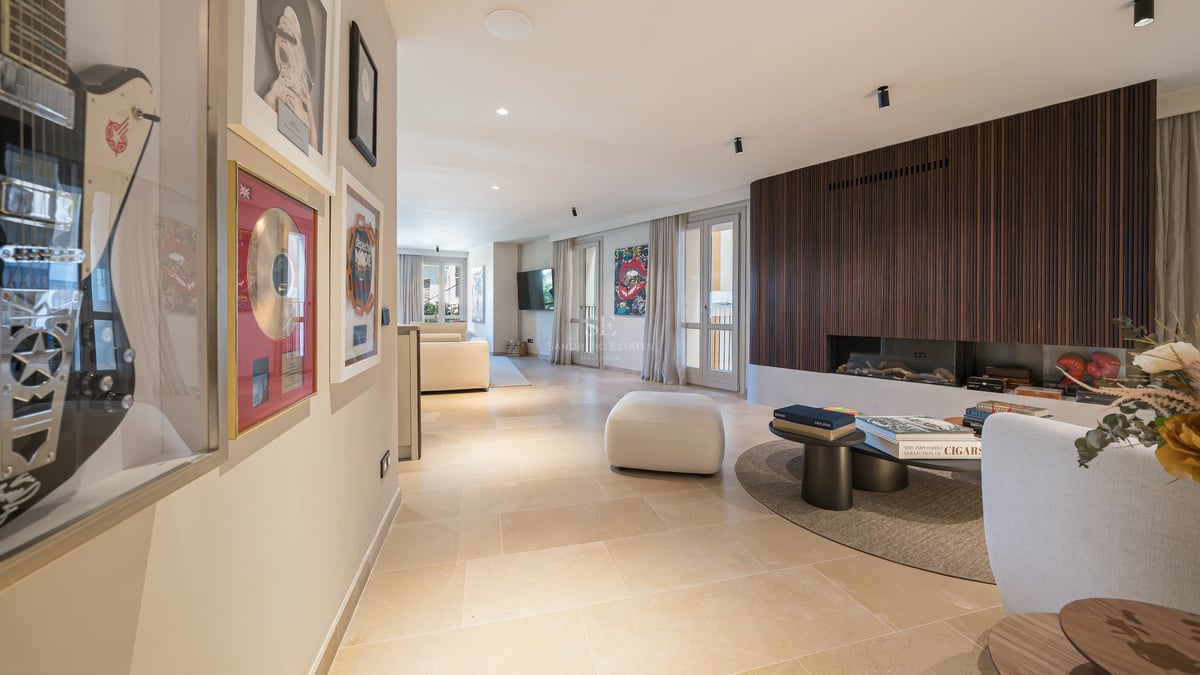 Séjour moderne avec mur en lattes de bois, cheminée, sol en pierre et décoration artistique.