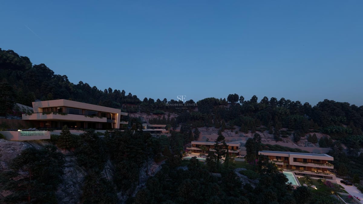 Villas de luxe nichées dans une colline verdoyante avec fenêtres éclairées sous un ciel de crépuscule.