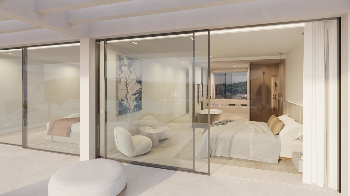 Hauptschlafzimmer mit bodentiefen Glastüren, neutralem Dekor und freistehender Badewanne im Hintergrund.