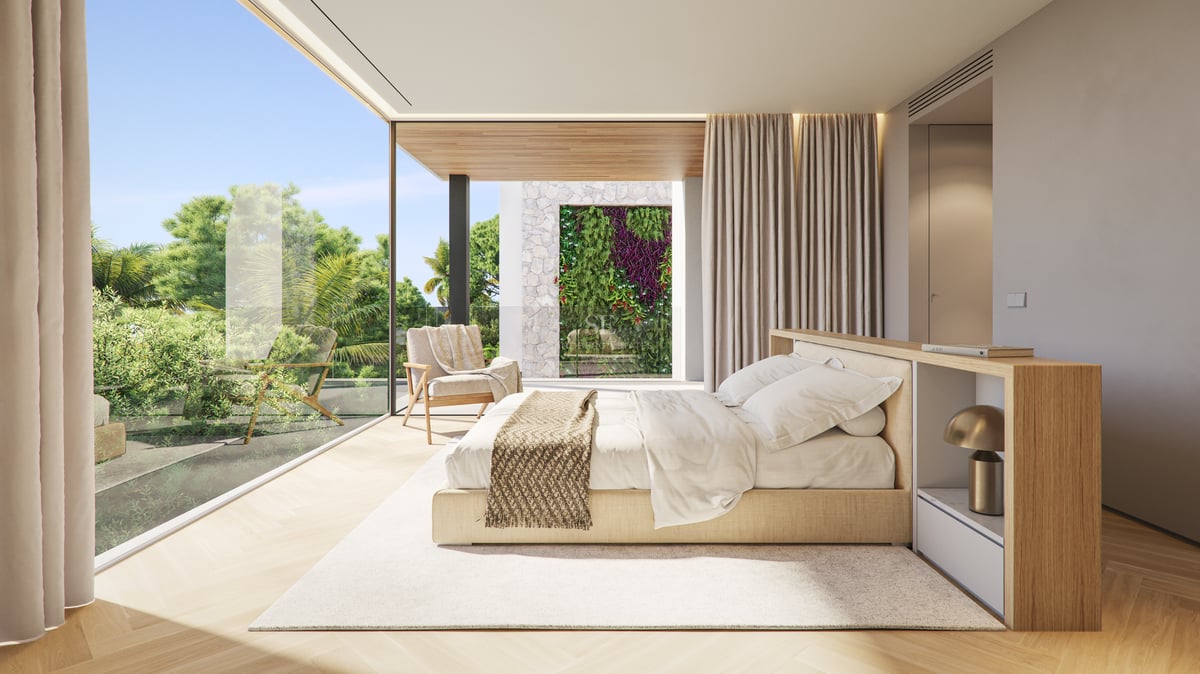 Modern master bedroom with floor-to-ceiling glass walls, king-size bed, and views of a lush tropical garden.