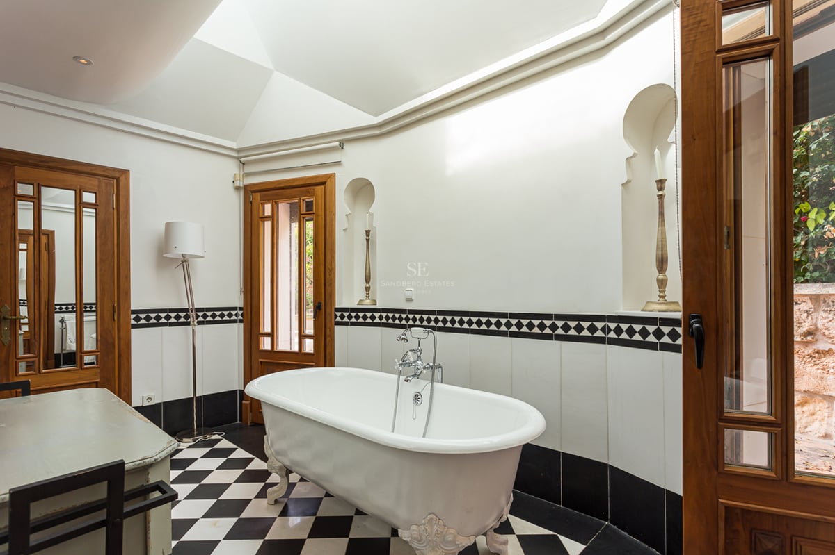 Extérieur de villa moderne avec piscine à débordement, grandes terrasses, et design architectural minimaliste. Végétation luxuriante et vues panoramiques.