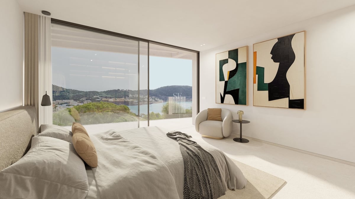 Modernes Hauptschlafzimmer mit großen Glasfronten und Blick auf die Küste und das Meer.