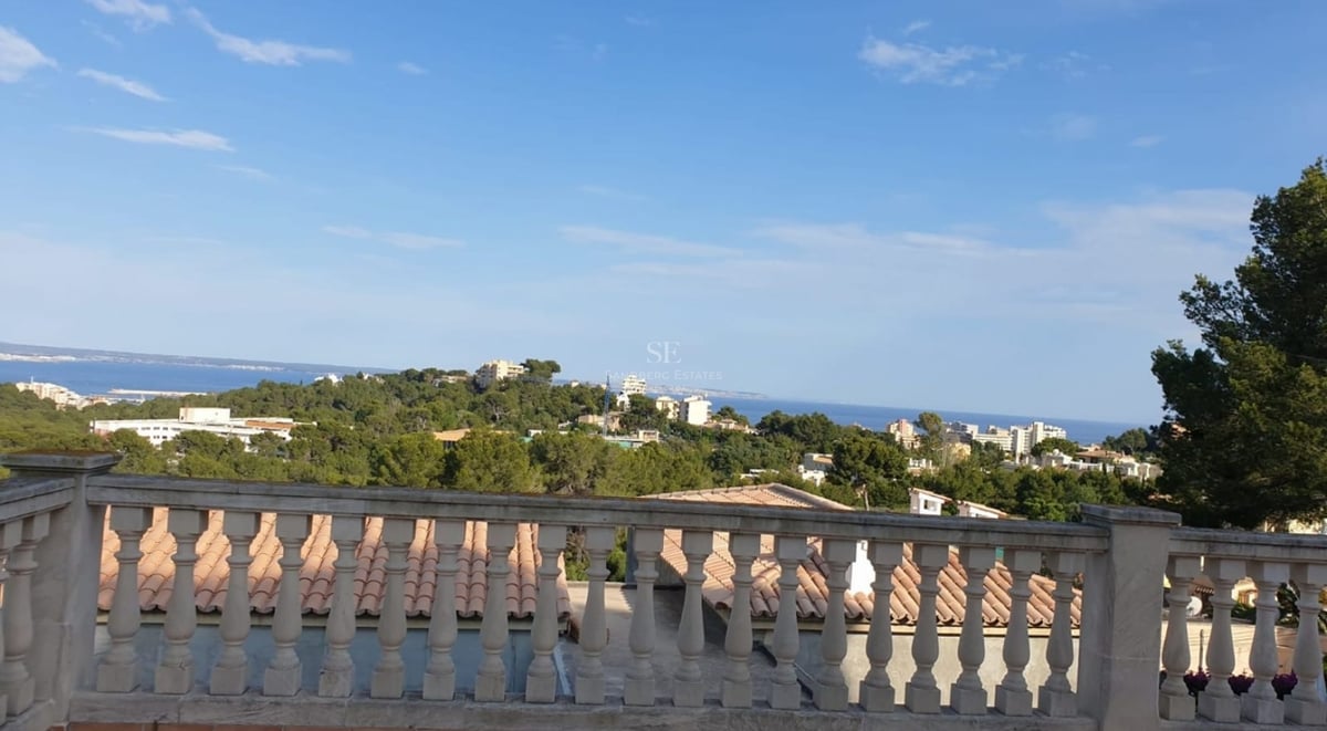 Spacious balcony with sea view and pool. Modern architecture featuring glass railings and stylish outdoor furniture.