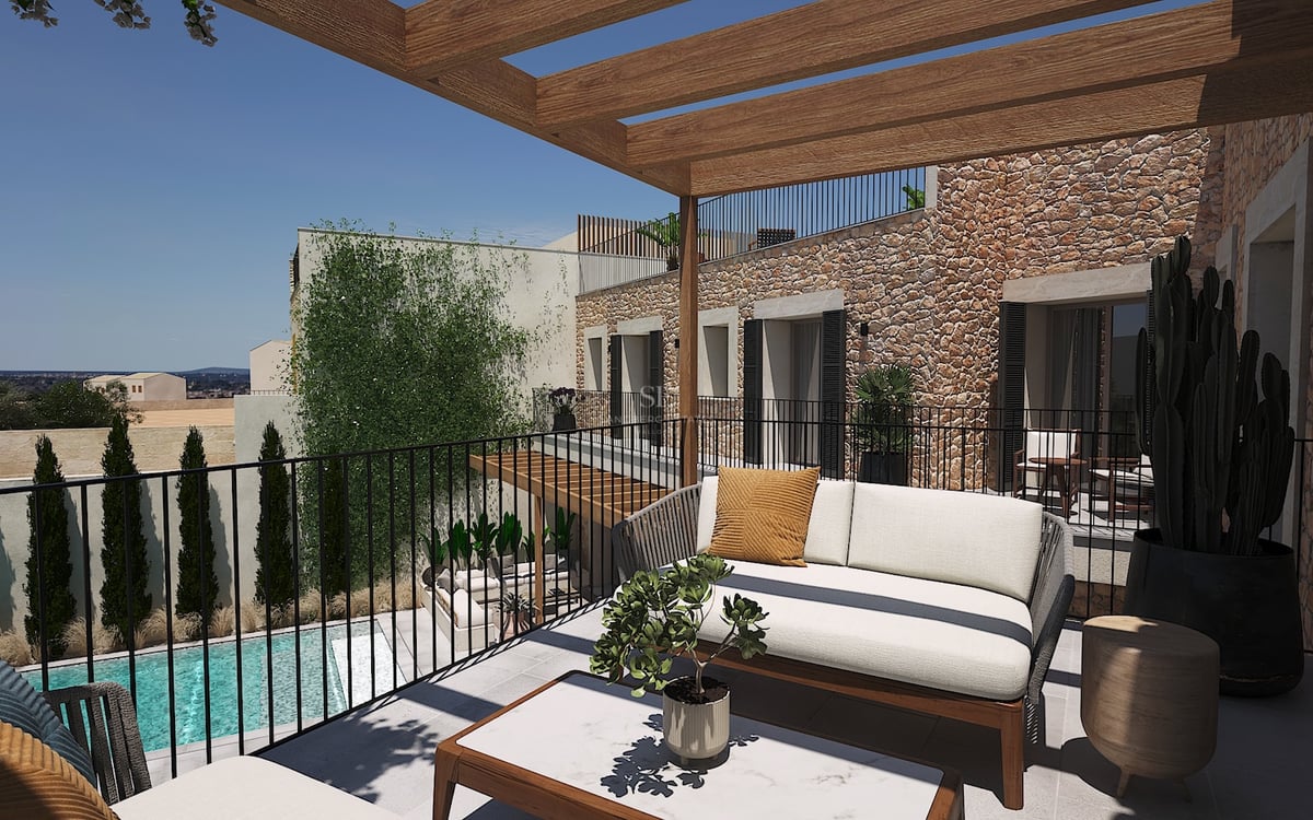 Terrasse contemporaine avec pergola en bois, canapé design et mur en pierre naturelle surplombant une piscine.