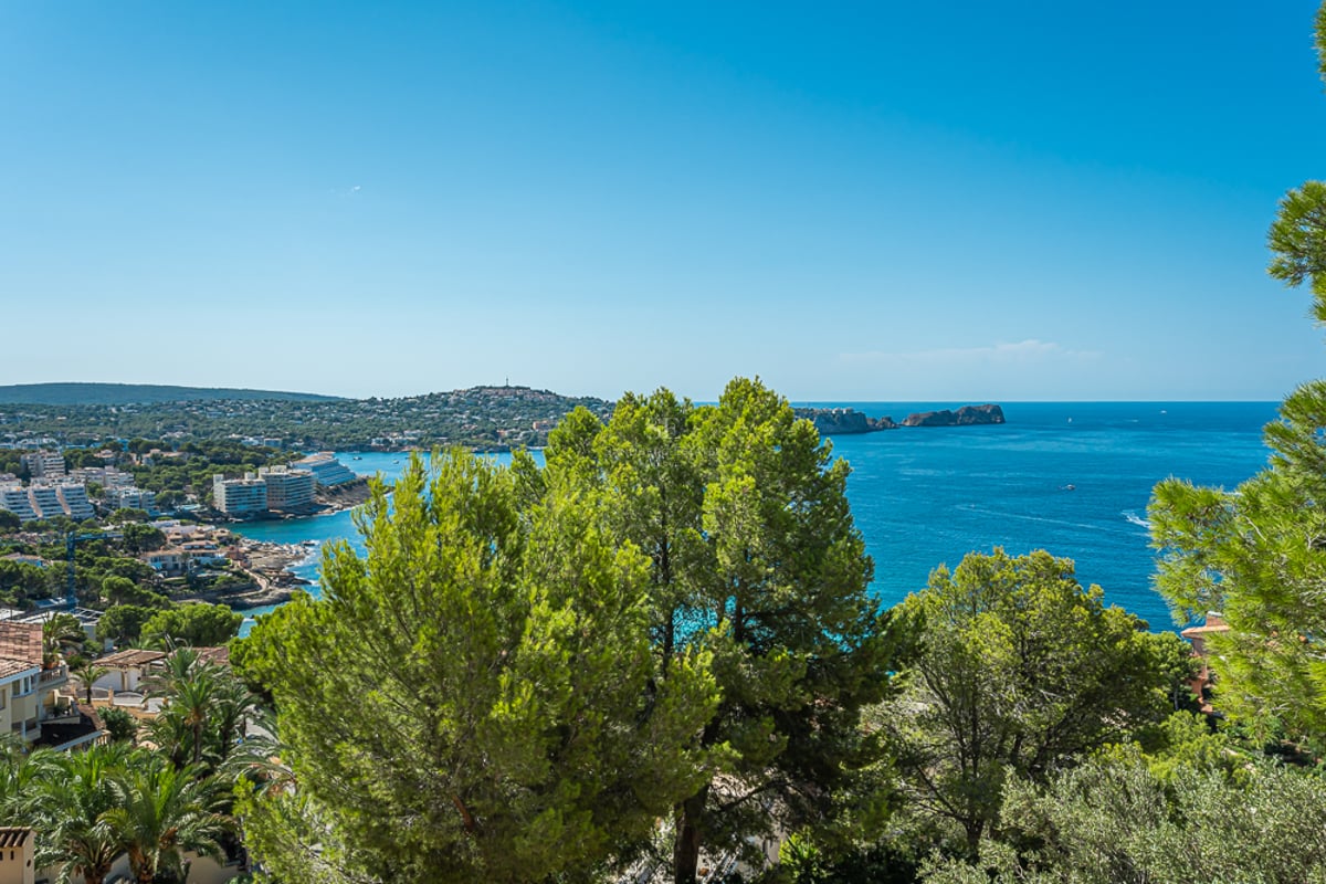 Wide view of a modern balcony with pool and sea view. Minimalist design, abundant natural light, and luxurious finishes.