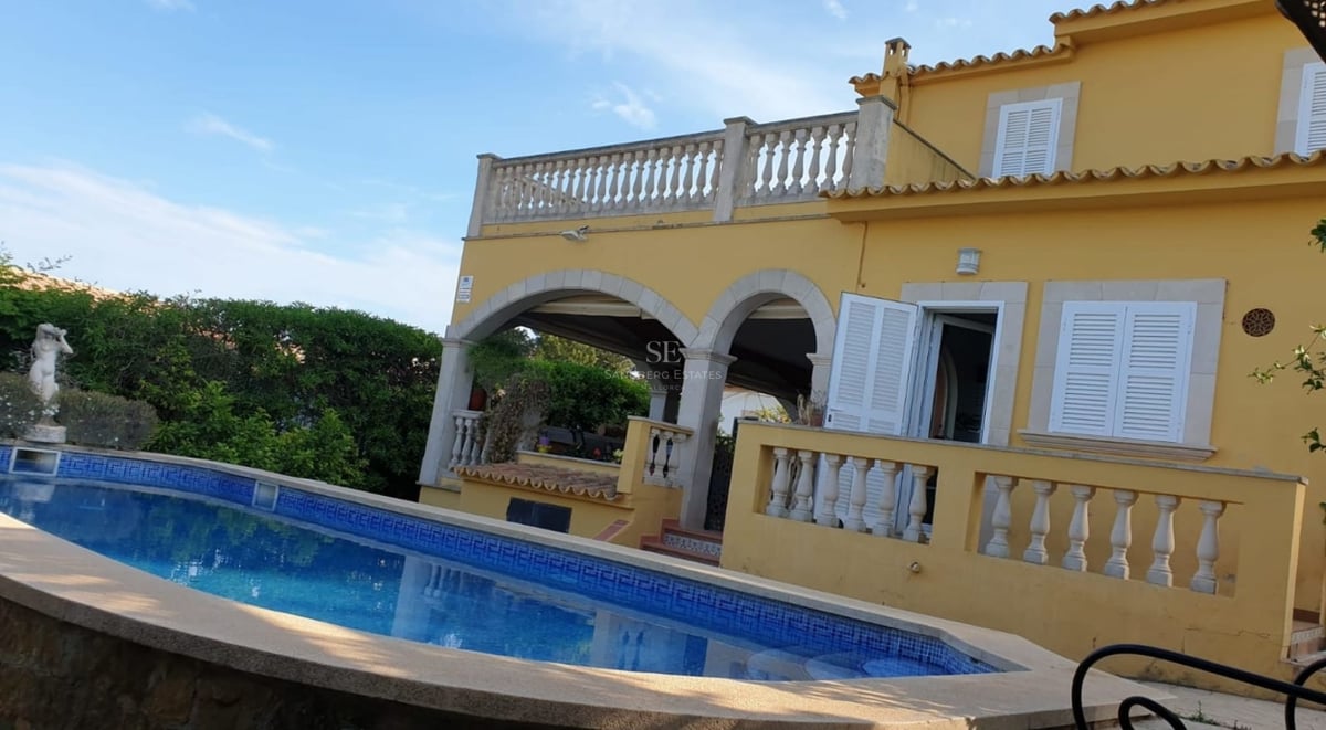 Spacious living room with outdoor pool, modern design, large windows, natural light and high-end furniture. Minimalist style.