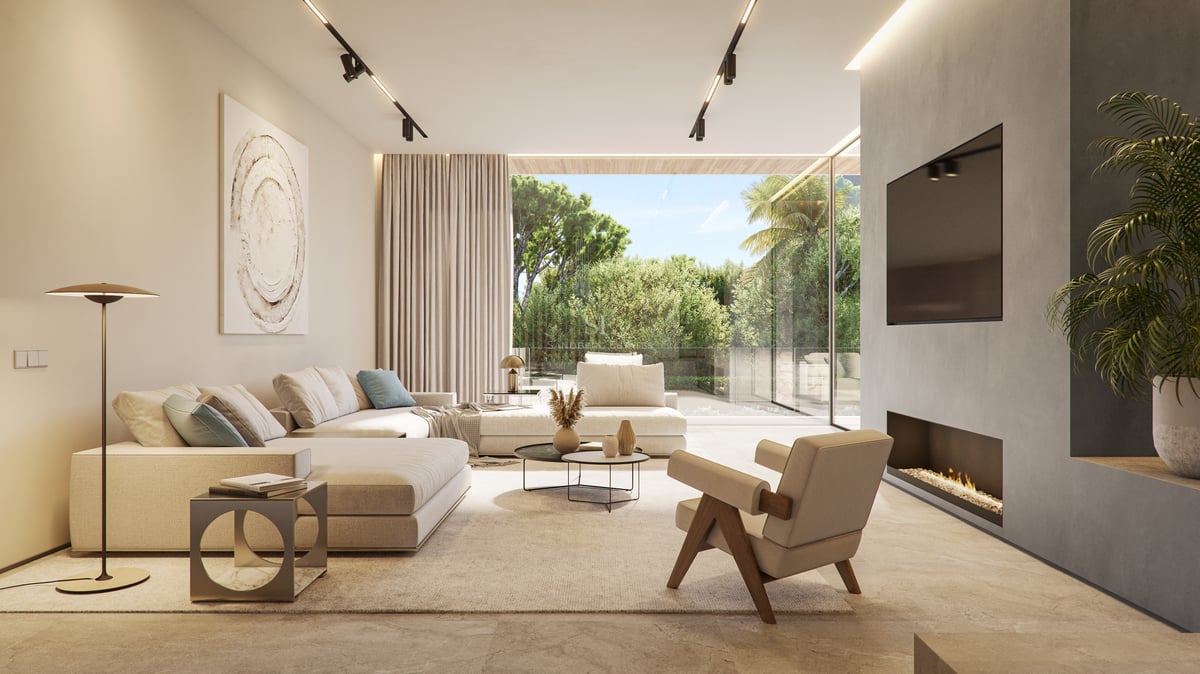 Modern living room with beige sofas, designer armchair, and floor-to-ceiling windows overlooking lush greenery.