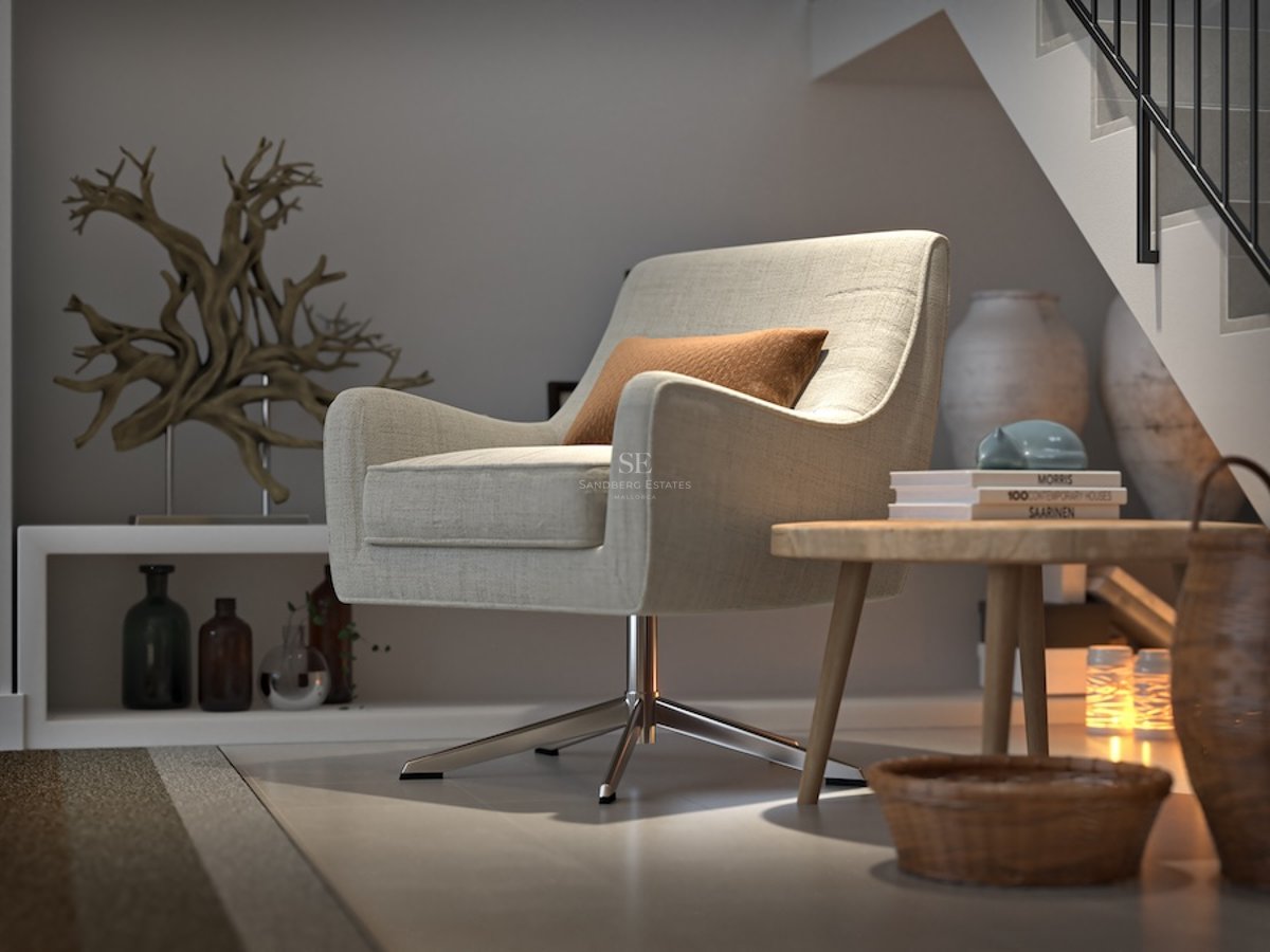 En beige snurrfåtölj i en minimalistisk nisch under en trappa med träbord och dekorativa föremål.