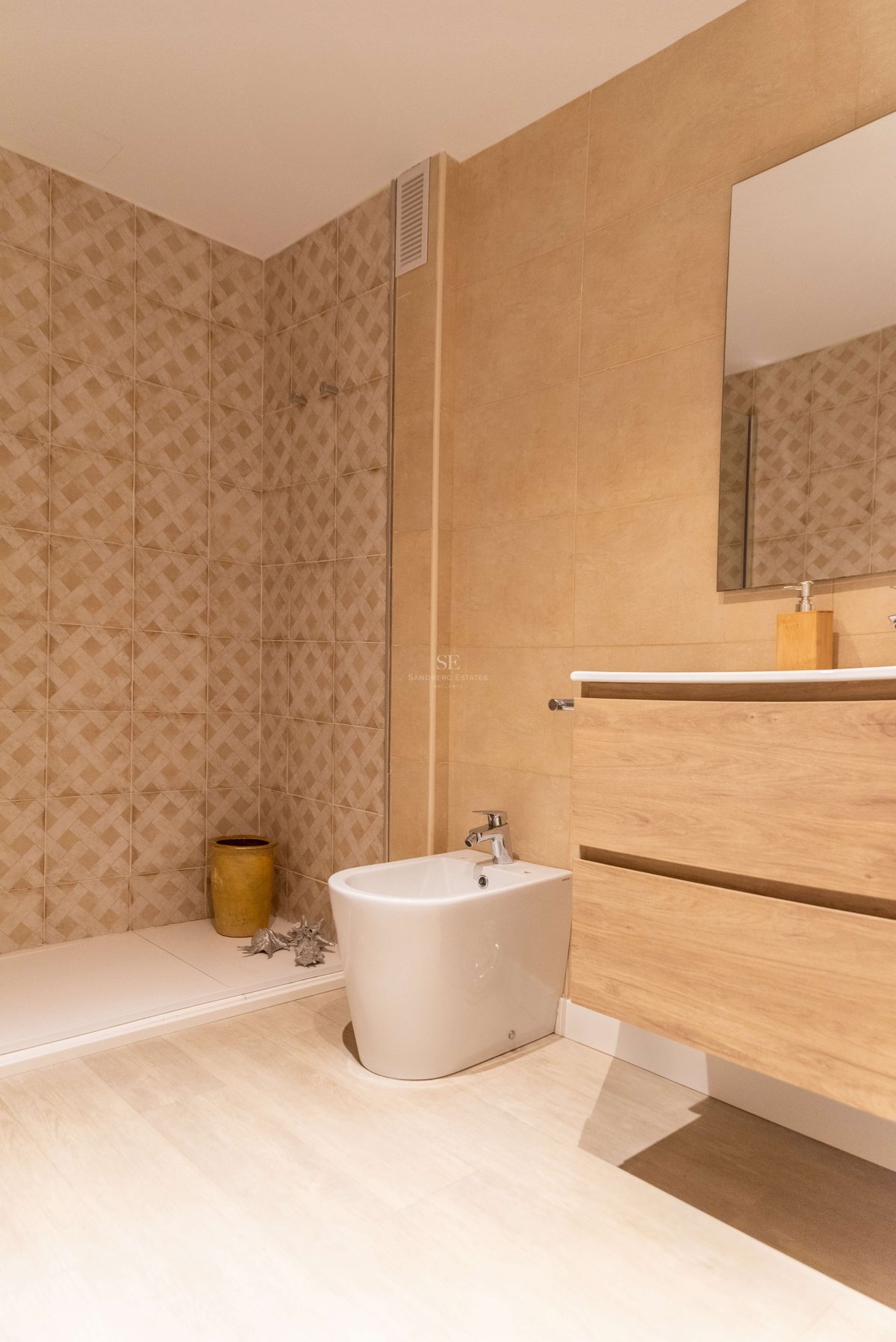 Zeitgenössisches Badezimmer mit sandfarbenen Fliesen, begehbarer Dusche, schwebendem Holzwaschtisch und weißem Bidet.