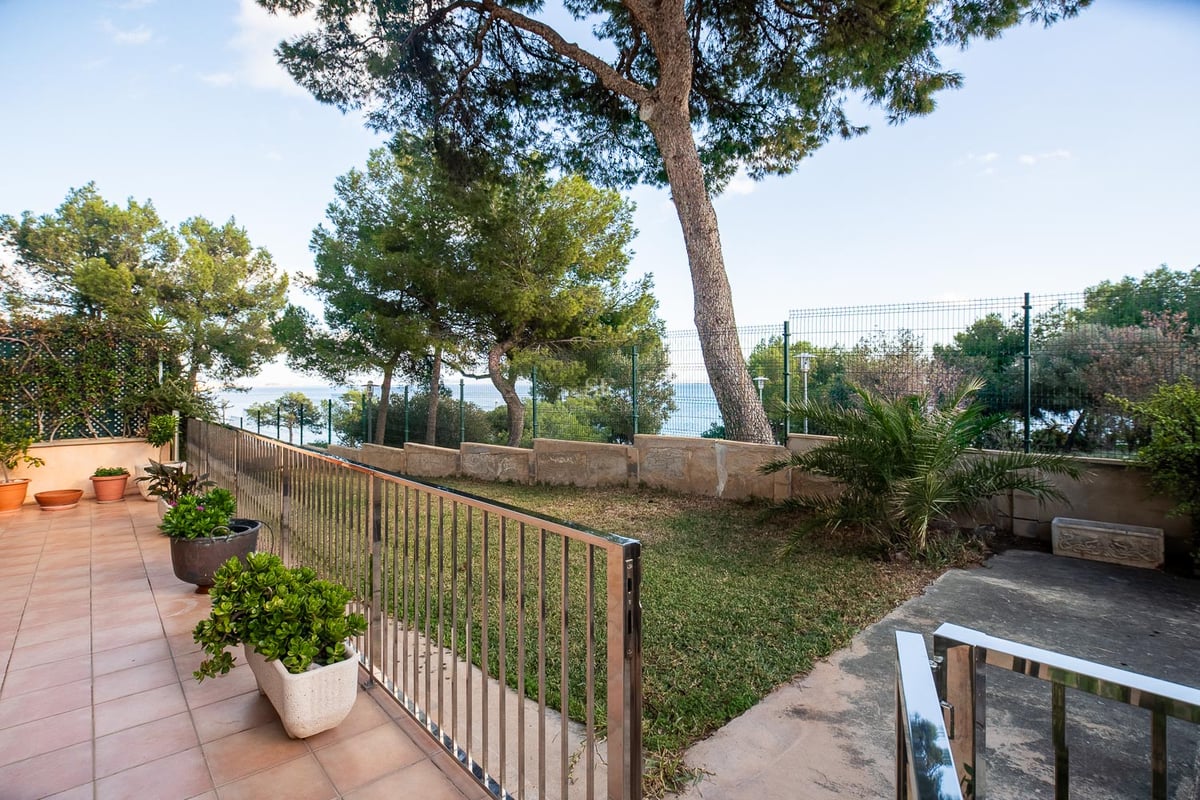 Terrakotta-Terrasse mit Blick auf einen privaten Garten mit Pinien und dem Mittelmeer im Hintergrund.