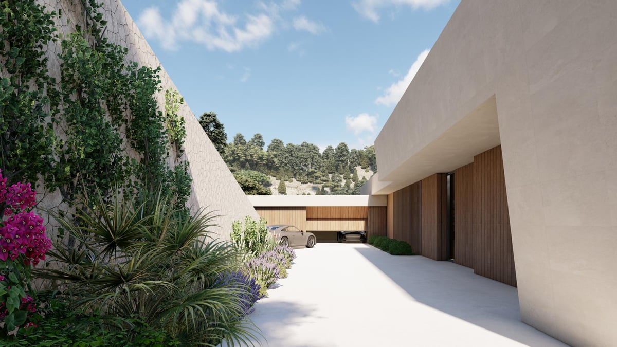 Allée de villa de luxe avec murs en pierre naturelle, portes de garage en bois et bougainvilliers.