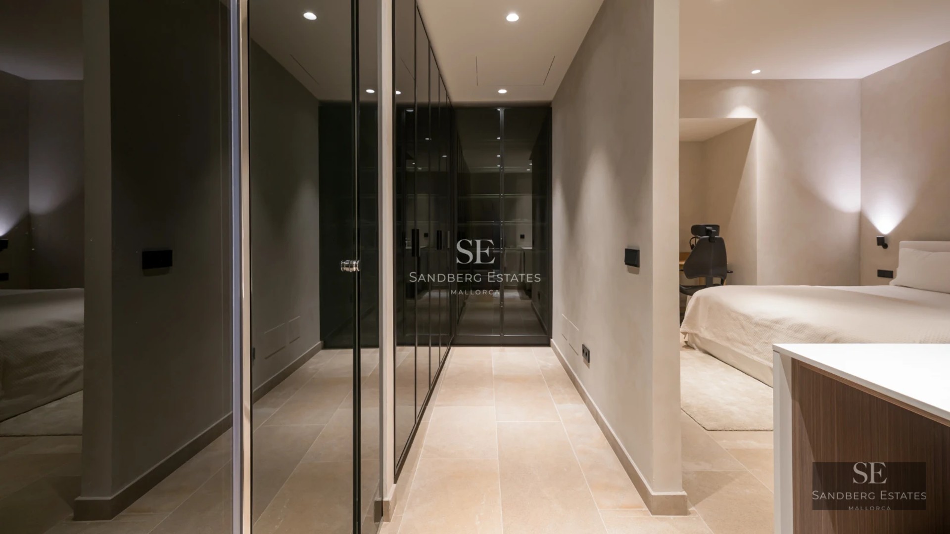 Spacious balcony with glass railing and panoramic sea view. Modern and elegant furniture, warm lighting.