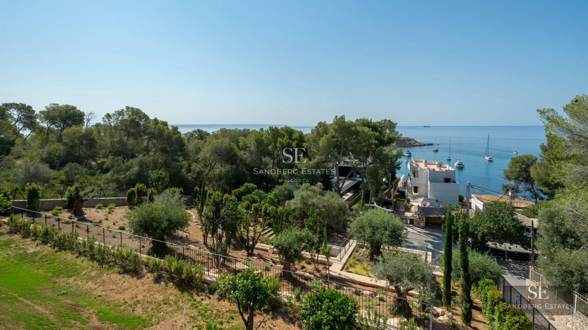 View of a modern infinity pool, surrounded by greenery, with a contemporary design house in the background.