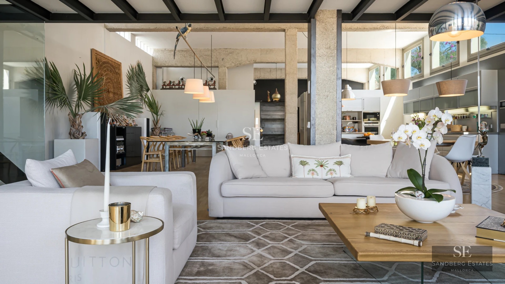 View of modern villa with infinity pool and lounge chairs. Minimalist architecture with large windows. Manicured garden and blue sky.
