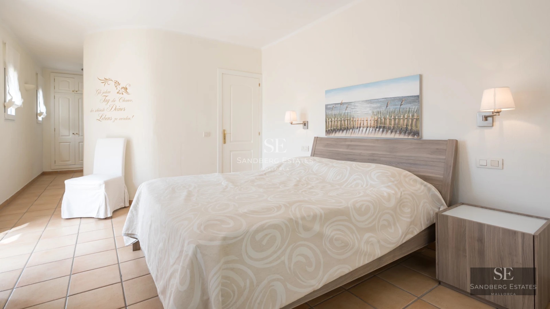 Spacious living room with large windows, modern furniture, and access to balcony with sea view. Natural lighting.