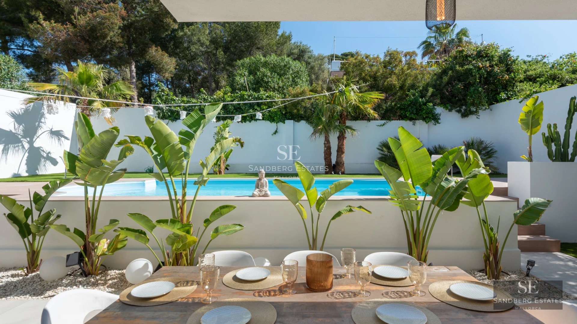 Spacious living room with floor-to-ceiling windows, designer sofa, and modern rug. Natural light and garden view.