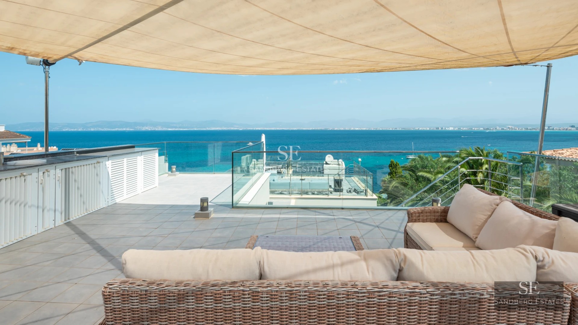 Exterior view of a modern villa featuring an infinity pool, manicured garden, and spacious terraces. Contemporary architecture with large windows.