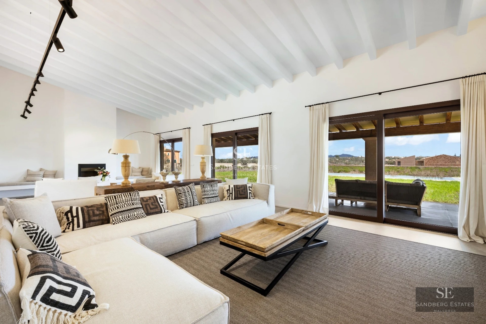 Spacious living room featuring panoramic windows, light wood flooring, and stunning ocean views. Modern and bright design.