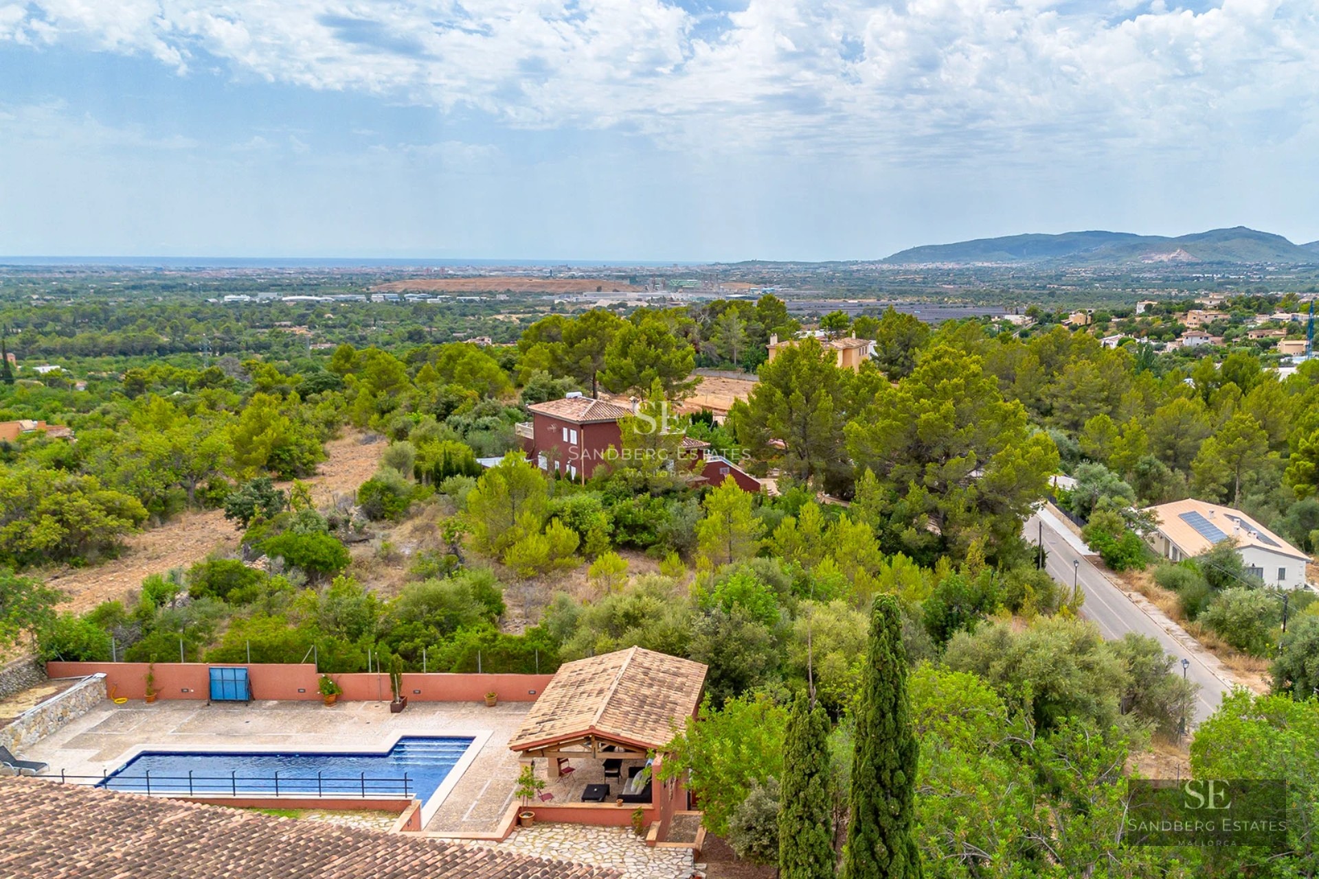 Spacious living room with fireplace, panoramic windows, warm lighting, and designer furniture. Views of the garden and pool.