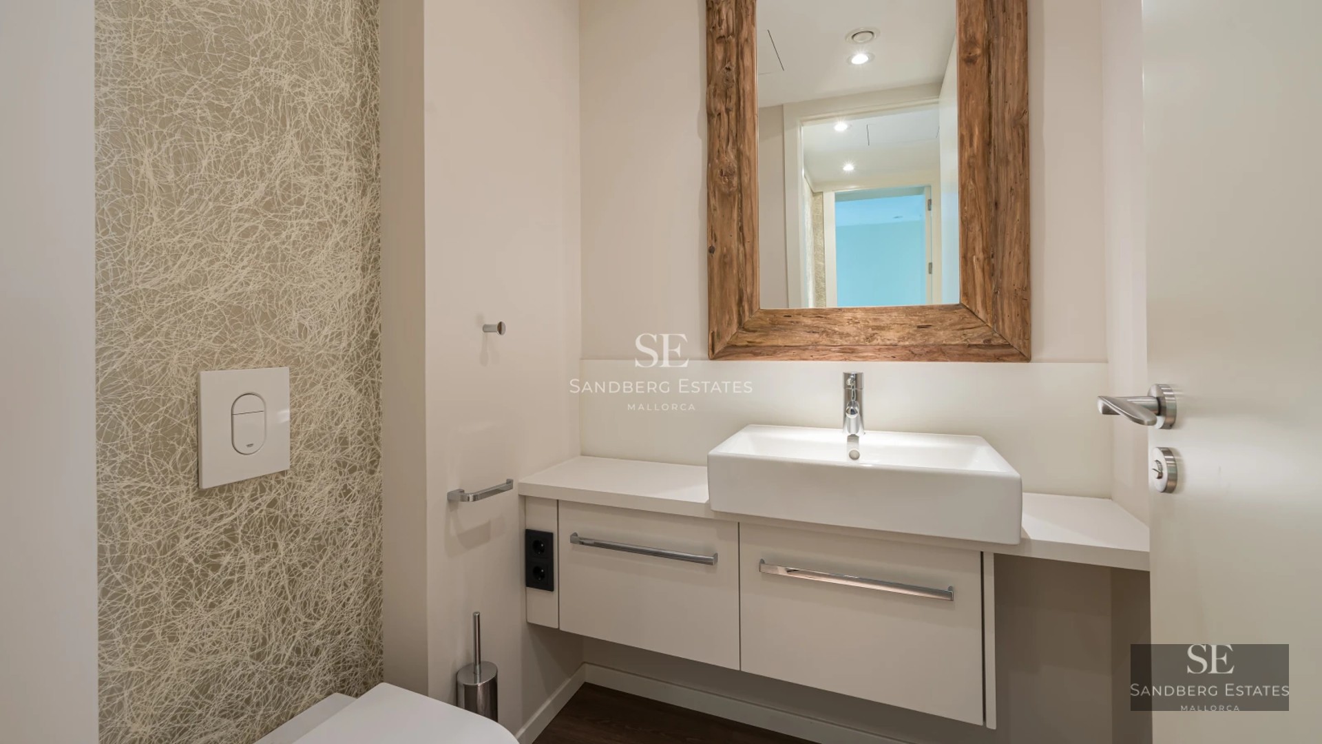 Modern balcony featuring glass railings, sea views, stylish furniture, and wooden flooring. Soft lighting and relaxing ambiance.