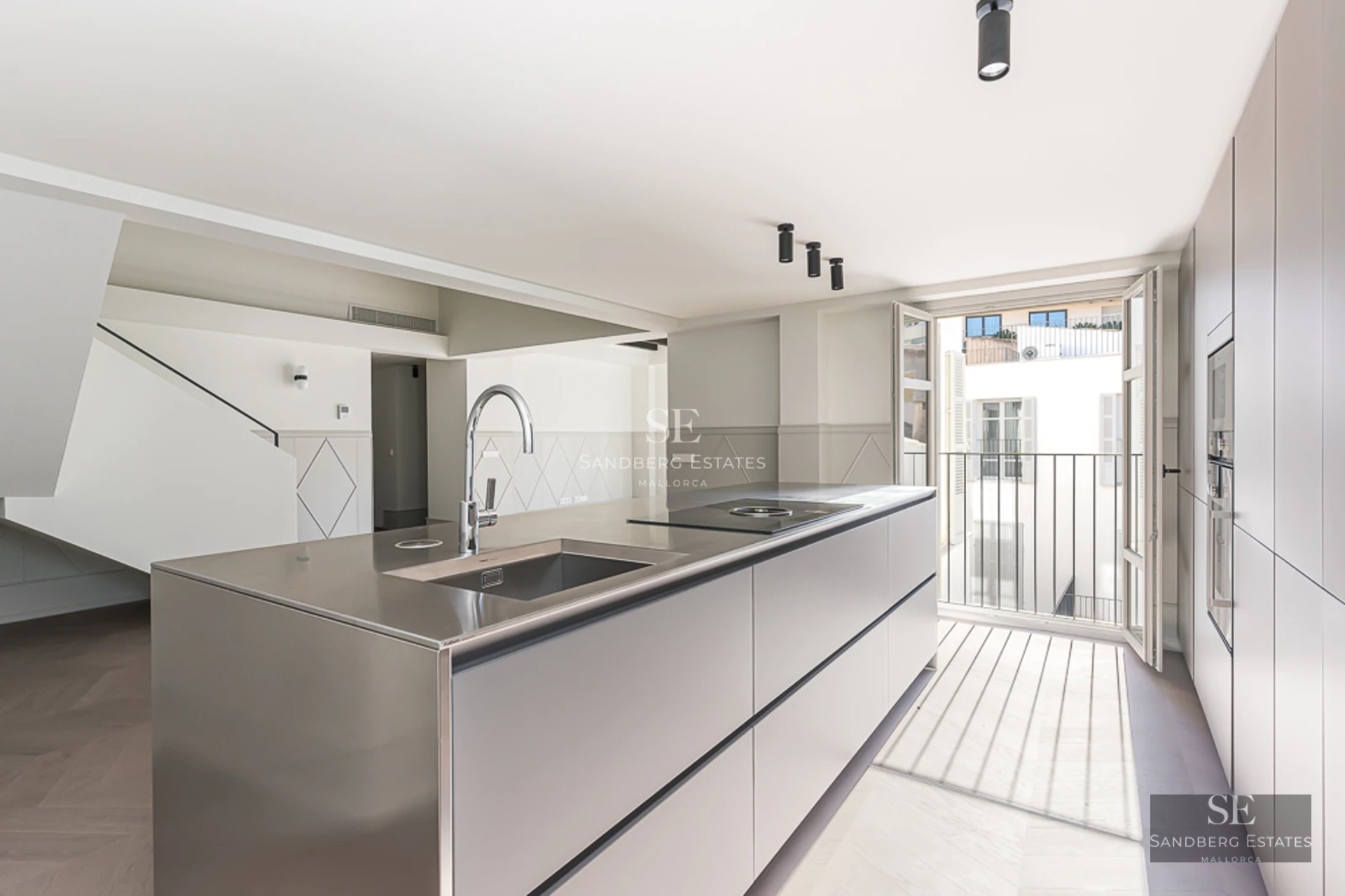 Spacious living room with picture windows, sea views and modern furniture. Light wood floors and neutral color palette.