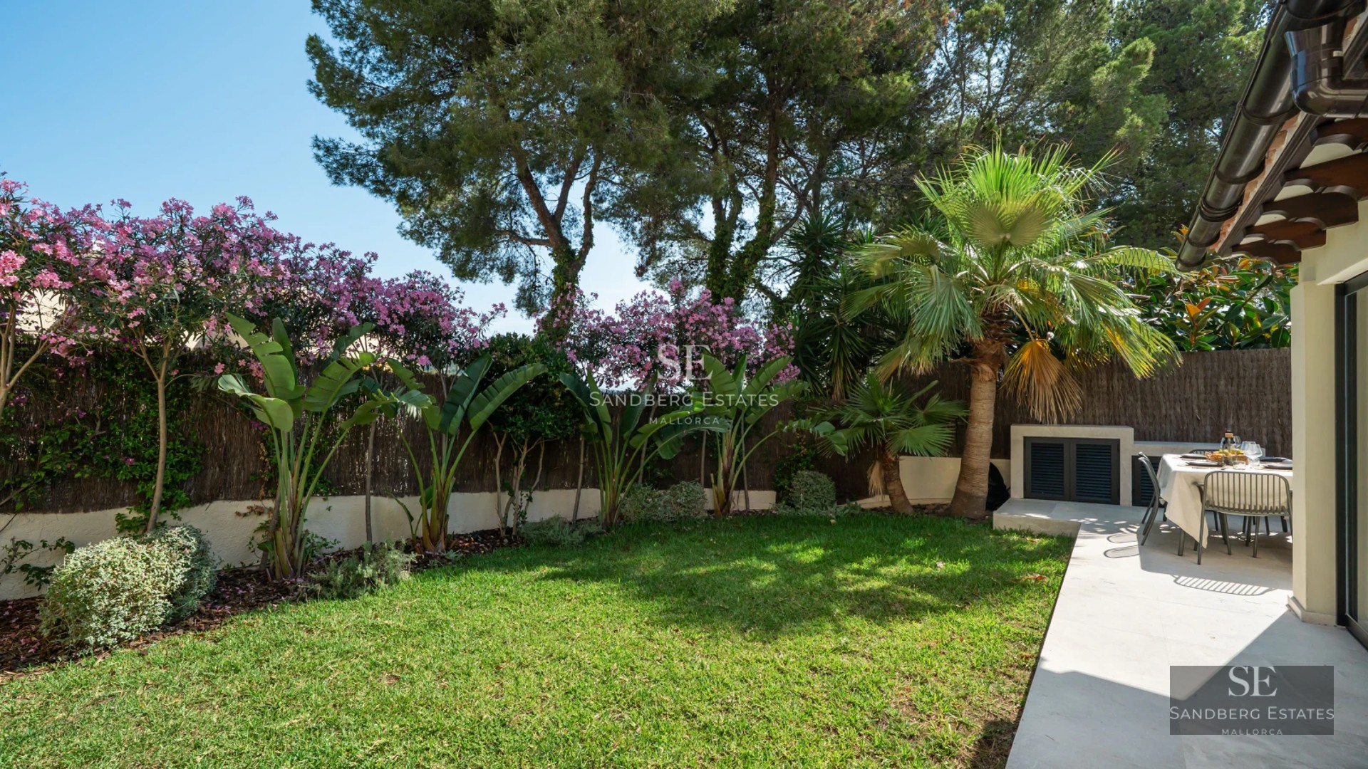 Panoramic view of an infinity pool with natural stone border and landscaped surroundings. Modern and minimalist design.