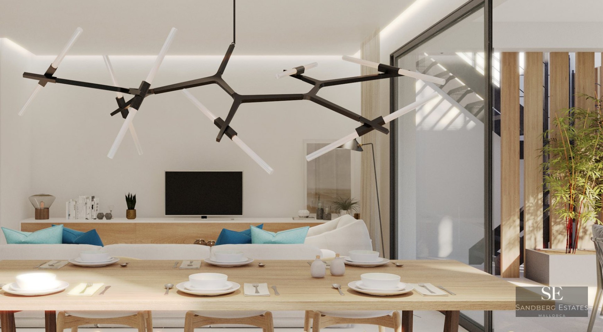 Modern dining table with white settings under a branch chandelier, overlooking a white sofa and TV in a bright room.