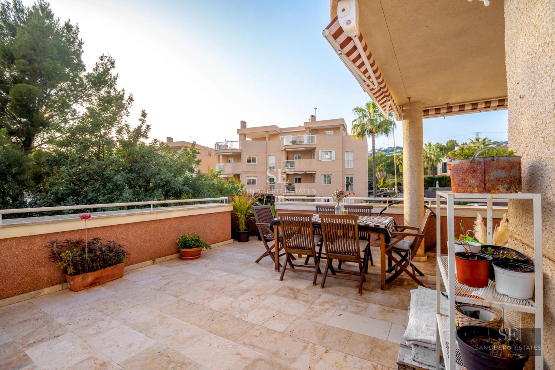 Grand balcon avec vue panoramique sur la mer. Garde-corps en verre, sol en bois et mobilier moderne. Lumineux et spacieux.