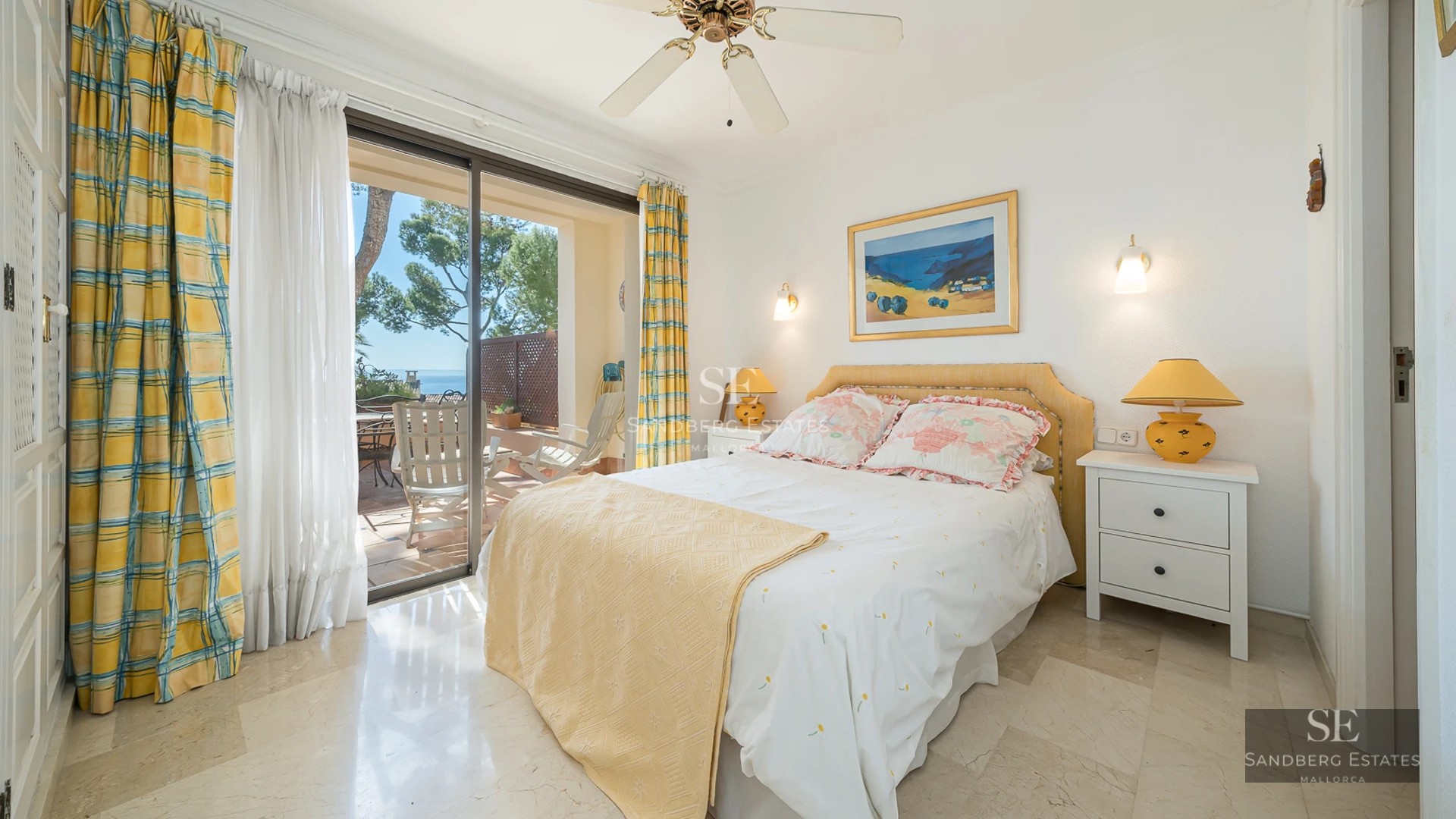 Spacious living room with panoramic sea views. Gray modular sofa, light rug, warm lighting, modern and elegant design.