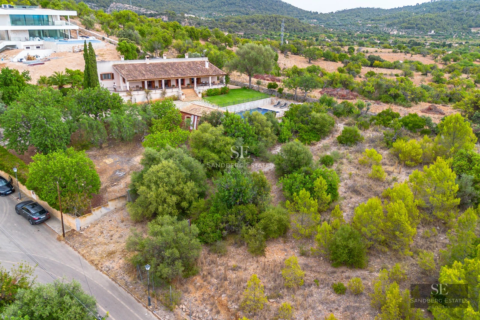 Bright living room with large windows, sea view, modern furniture, and balcony access. Light wood flooring.