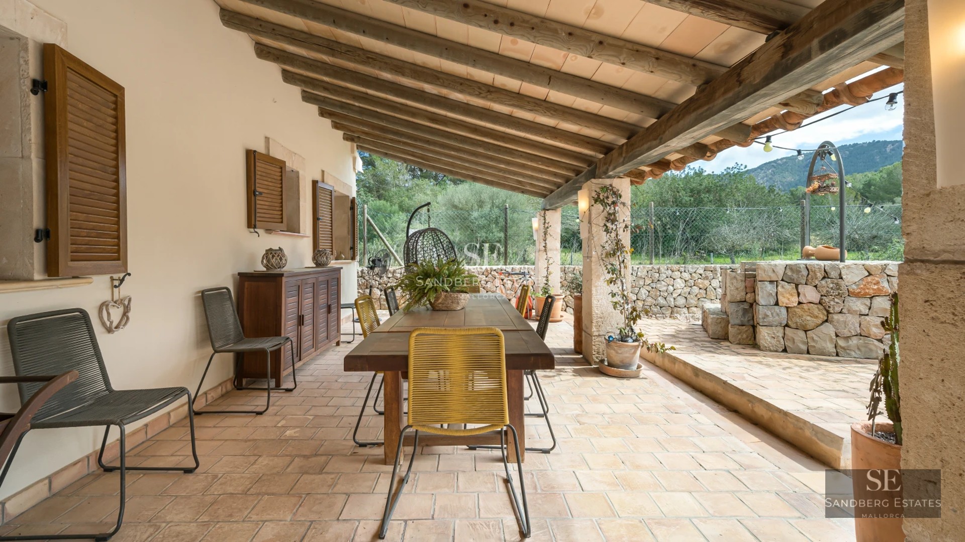 Spacious living room with fireplace, large windows, wood floors, and light walls. Modern sofa and minimalist decor.